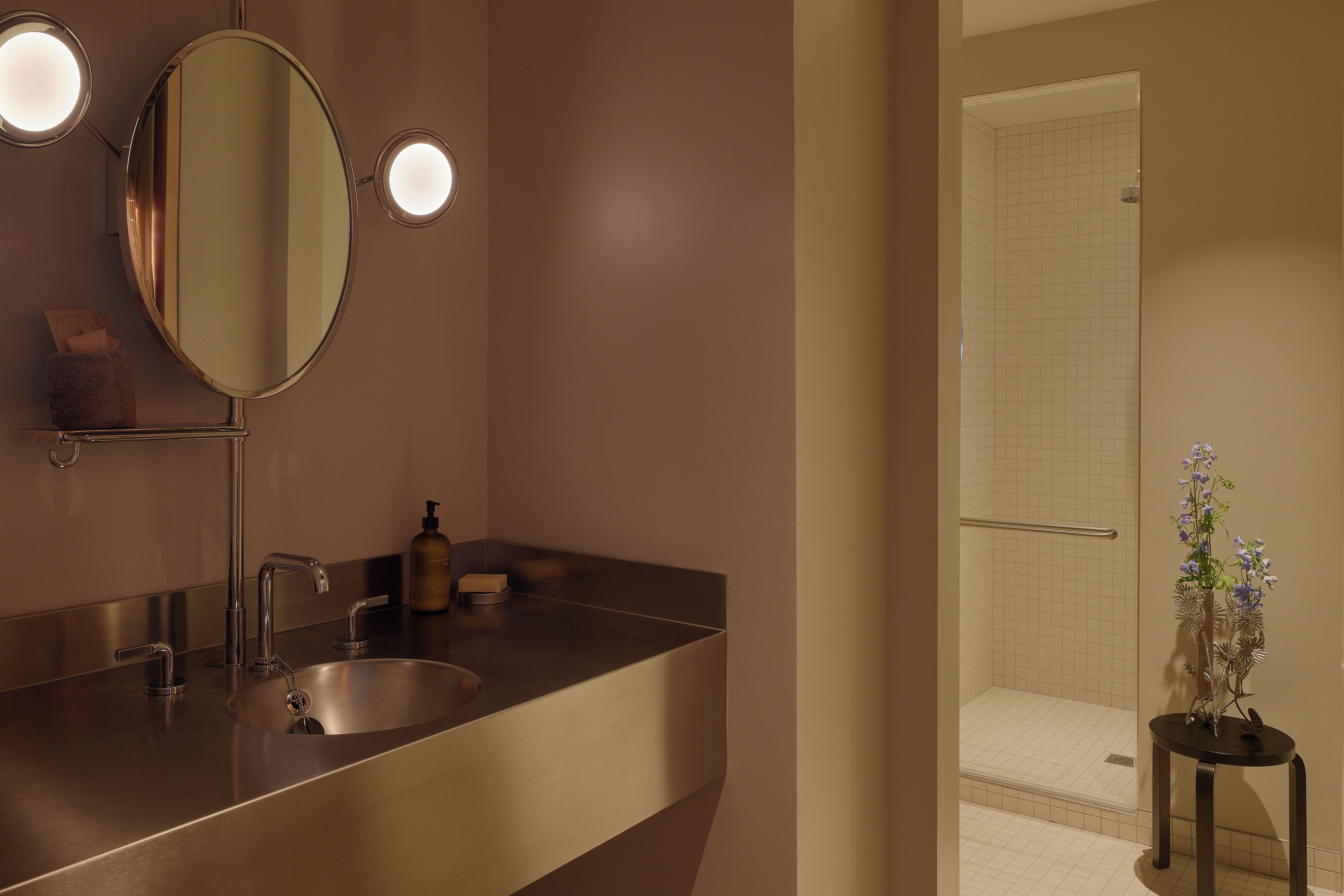 Un baño con lavamanos, espejo y ducha.