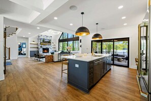 A spacious kitchen with a central island, pendant lighting, and a view to the outdoors.