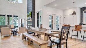 A spacious dining area with a wooden table set for four, surrounded by chairs.