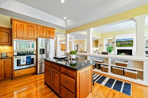 Una cocina moderna con armarios de madera, electrodomésticos de acero inoxidable y una isla central.
