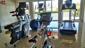 A gym with stationary bikes, a treadmill, and a rowing machine.