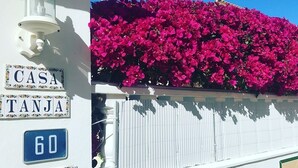 Un bâtiment à la façade blanche, un panneau de rue indiquant « CASA TANJA » et un panneau bleu avec le numéro de la maison : « B20 ».