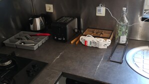 Eine Küche mit Gasherd, Toaster, Wasserkocher und Spüle.