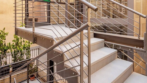 A modern outdoor staircase with metal railings and a glass enclosure, leading to a building with large windows. - IL GENIO Residenza d'Epoca (Pisa)