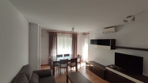 A living room with a sofa, TV, and a dining area with a table and chairs. - BENIVILLAGE (Benicarló)