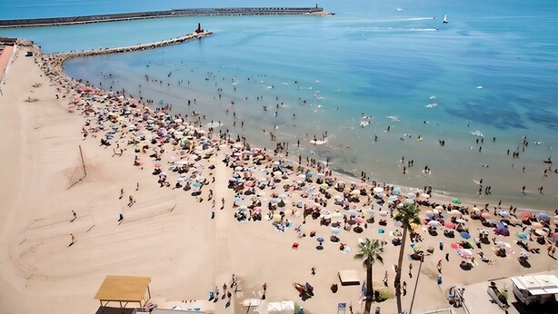 A beach with numerous umbrellas and people. - BENIVILLAGE (Benicarló)