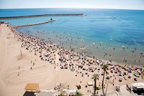 A beach with numerous umbrellas and people. - BENIVILLAGE (Benicarló)