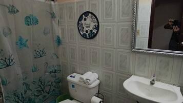 Une salle de bain équipée de toilettes, d’un lavabo et d’un rideau de douche sur le thème de la mer.