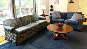 A living room with two sofas, a coffee table, and a lamp.