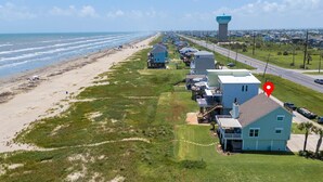 A coastal property with a beach view, a water tower, and a road running parallel to the beach. - Relaxing Beachfront Escape (Galveston)