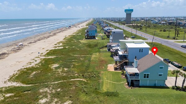 A coastal property with a beach view, a water tower, and a road running parallel to the beach.