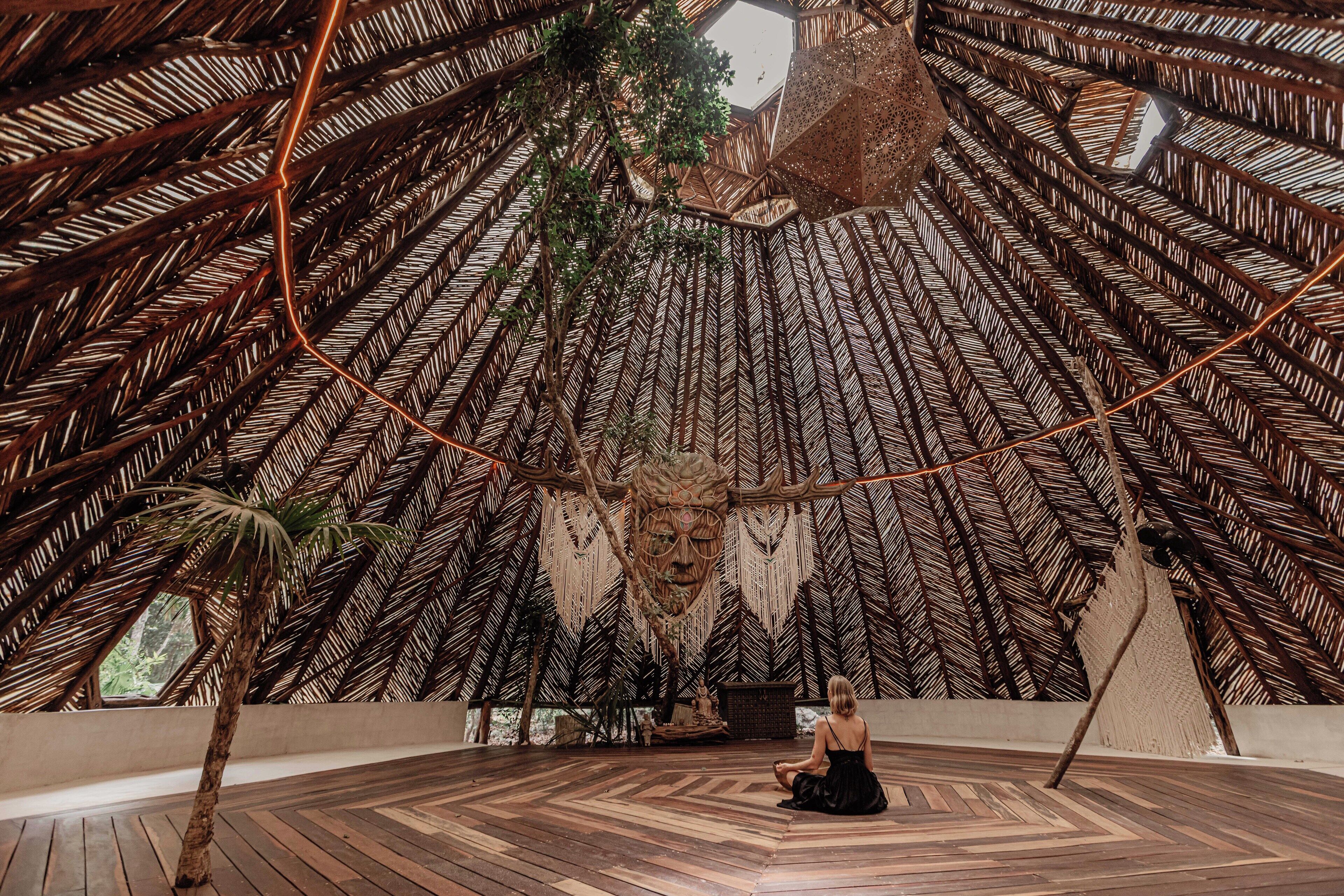 A room with a wooden floor, a central seating area, and a large, intricate wall design.