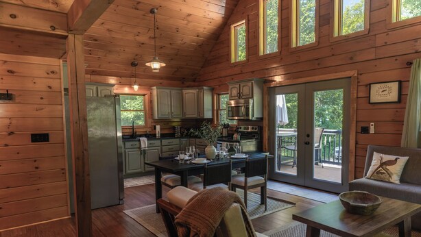 L’intérieur d’un chalet en bois comprend une cuisine, un coin repas et un espace salon confortable.