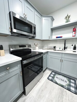 Een microgolfoven, een oven, een kookplaat, een vaatwasser