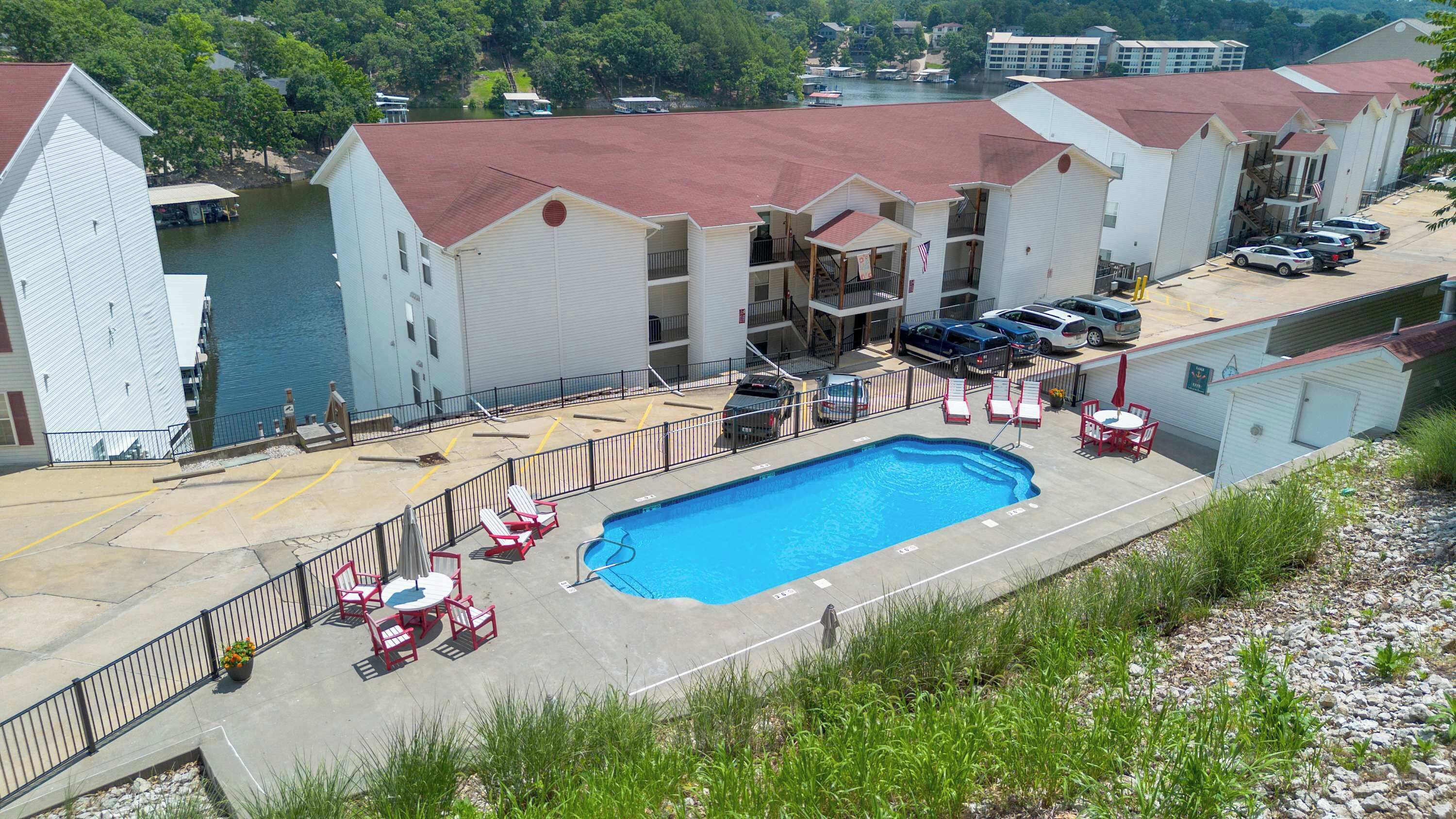 A hotel with a swimming pool, outdoor seating, and a view of a lake.
