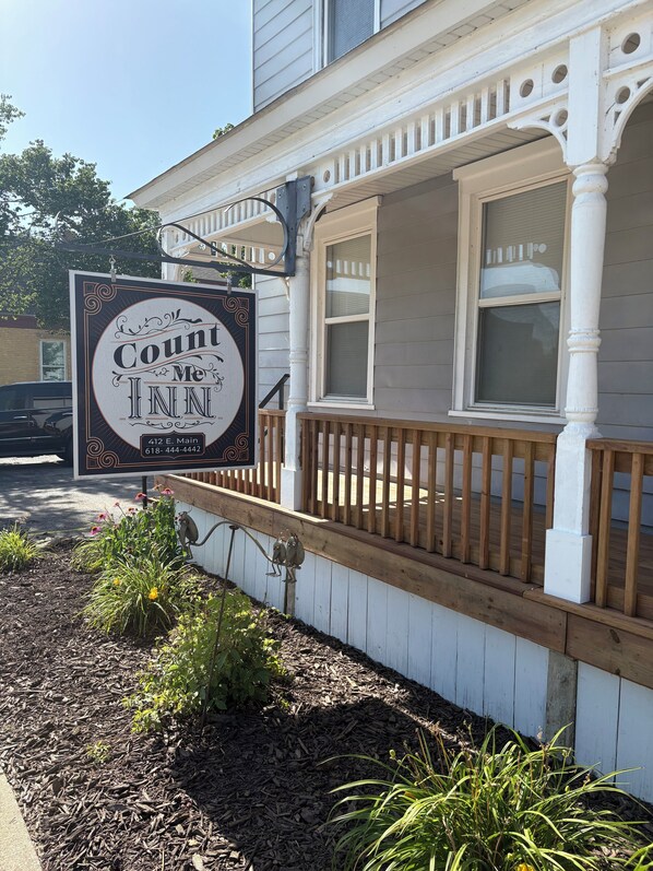 Un bâtiment doté d’un porche et d’une enseigne indiquant « Count Me Inn ».