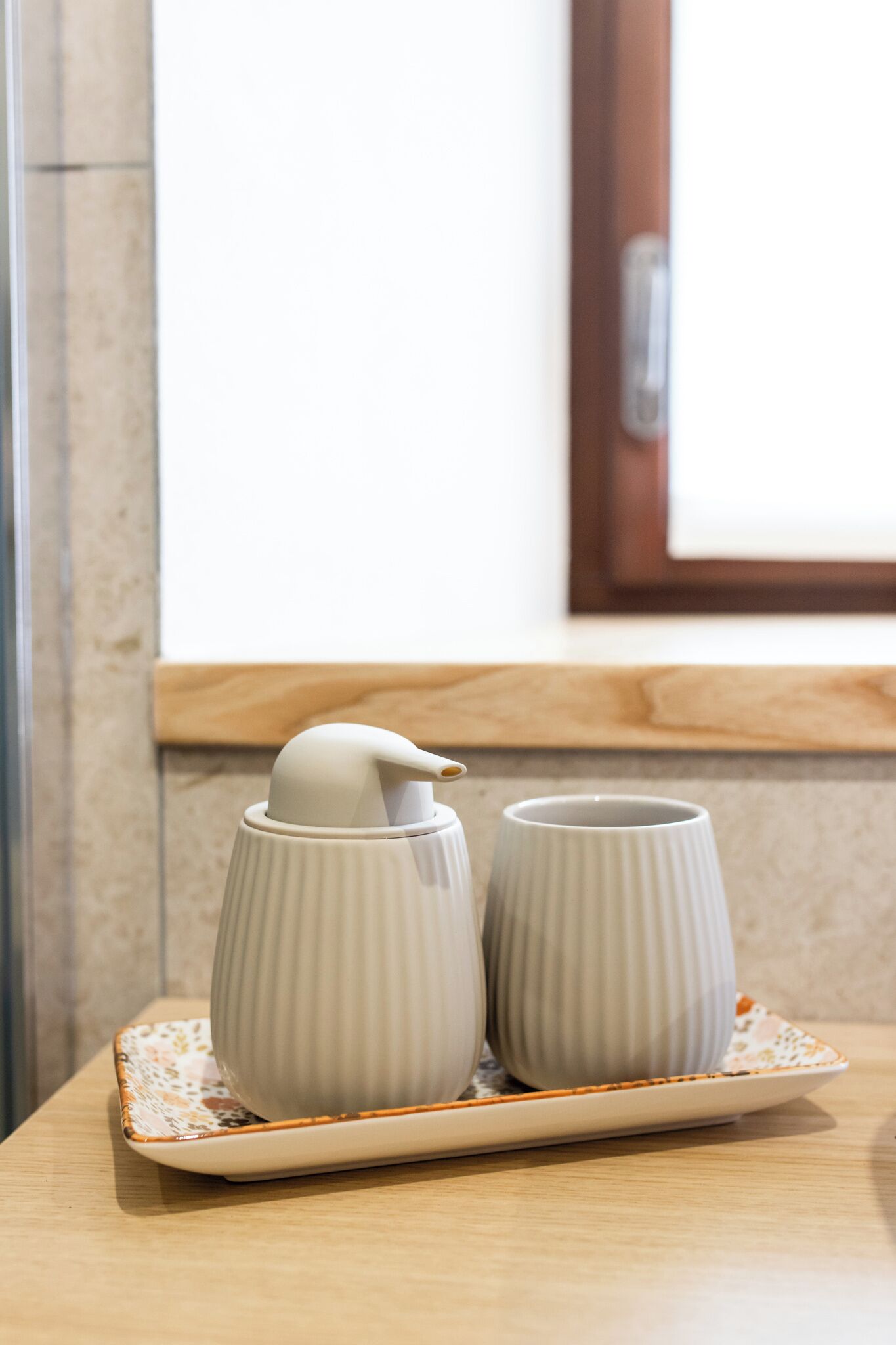 Una bandeja con dos tazas blancas de cerámica y un recipiente blanco de cerámica sobre una mesa de madera.