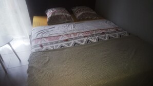 Un lit avec une literie à motifs, une tête de lit et des oreillers.