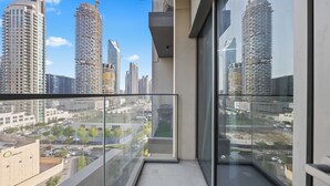 Un immeuble de grande hauteur doté d’un balcon en verre qui offre une vue sur le paysage urbain.