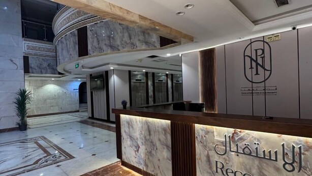 Un mostrador de recepción de mármol con un cartel que dice "Jalal U1 Reception".