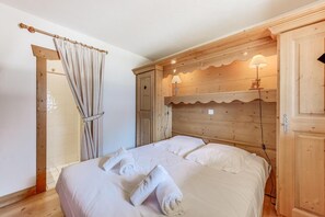A bedroom with a wooden headboard, a bed with white linens, and a wooden wardrobe. - Fitness, swimming pool, sauna, hammam, balcony, parking, tv, 58m², Champagny-en-Vanoise (Champagny-en-Vanoise)