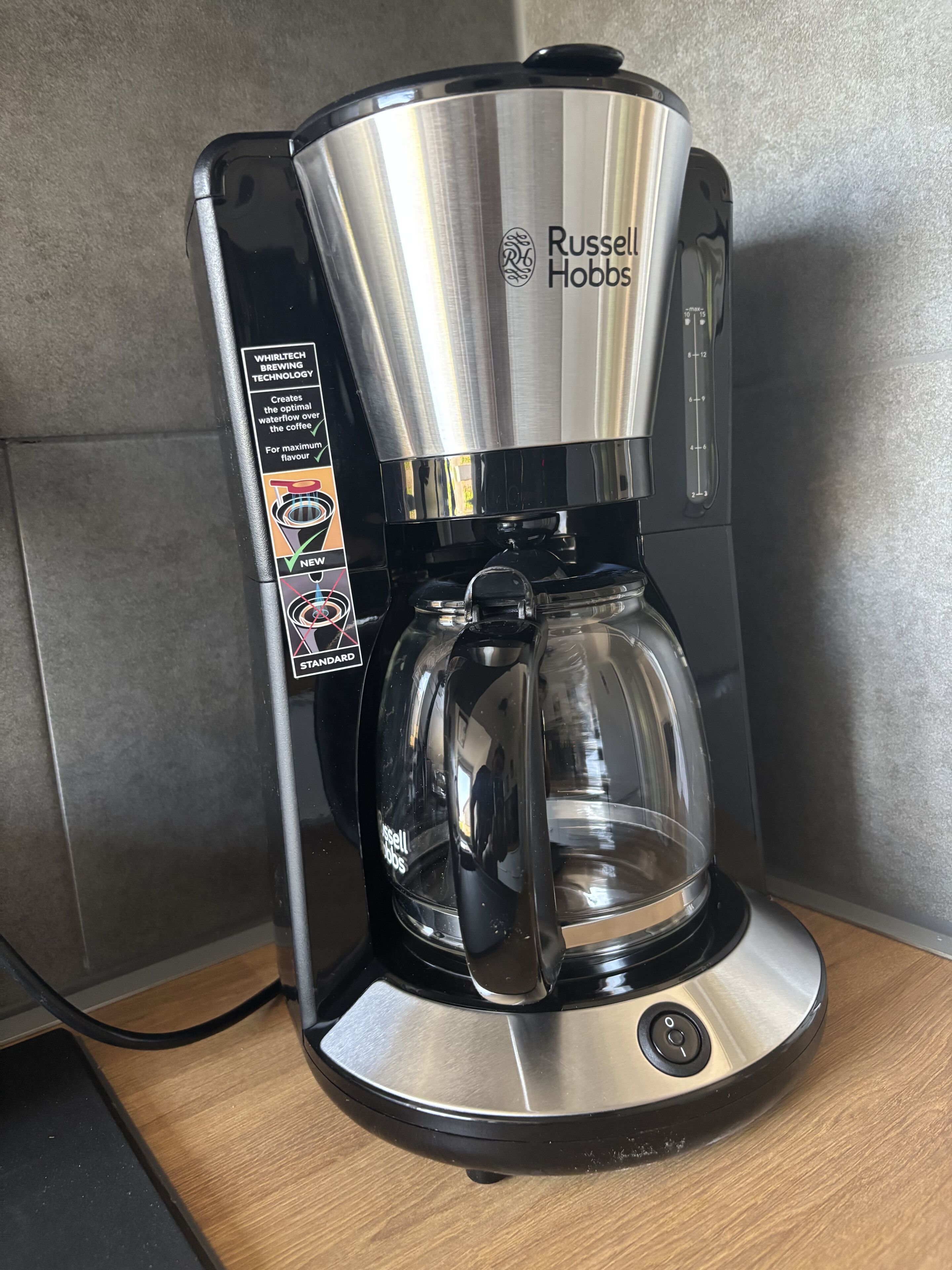 A Russell Hobbs coffee maker with a clear glass carafe, a stainless steel drip tray, and a black base.