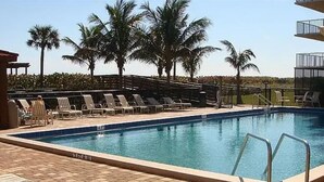 Ein Swimmingpool mit Liegestühlen und Palmen.