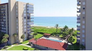 Ein Hochhaus mit mehreren Balkonen mit Blick auf Strand und Meer.