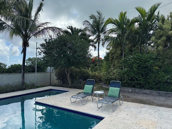 A swimming pool with two lounge chairs and surrounding tropical vegetation. - Cima del Mar
(Top of the Sea)
Hilltop, private 180 degree ocean view (Nassau)