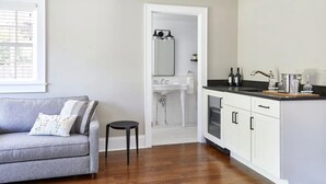 A modern kitchen with white cabinets, a black countertop, and a built-in oven. - The Kent Collection - The Firefly Inn (Kent)