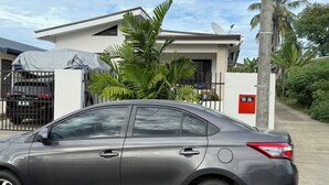 A modern two-story house with a garage, a satellite dish, and a gated driveway. - Cosy self contained studio apartment,5 mins from Nadi International Airport. (Nadi)