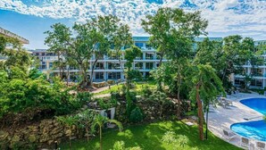 A resort with a pool, lush greenery, and modern buildings.