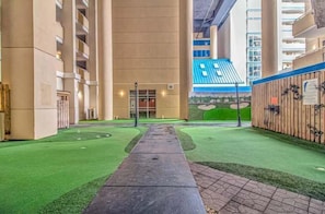 Ein Hotelkorridor mit Kunstrasen, einem Weg und einem blauen Schild.