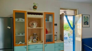Une cuisine avec des armoires de couleur turquoise, un mixeur et un réfrigérateur.