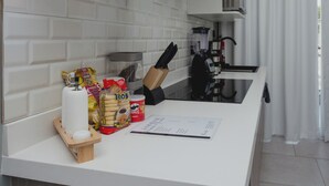 A modern kitchen with white cabinetry, a blender, a knife block, and various food items on the counter. - Apartamento Santa Rita #5 cerca de restaurantes (Danlí)