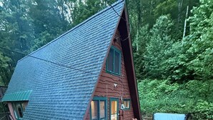 A wooden deck with Adirondack chairs, a fire pit, and a hot tub.