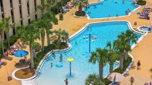 Ein großer Pool im Freien, umgeben von Palmen und Liegestühlen.