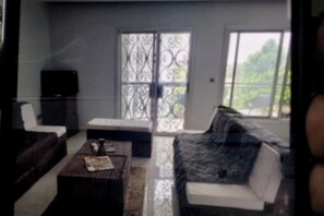 A living room with a sofa, a coffee table, and a television.
