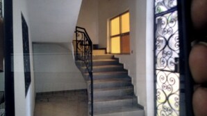 Un escalier avec une rampe métallique menant à un palier.