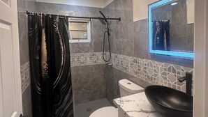 A bathroom with a shower, toilet, and sink.