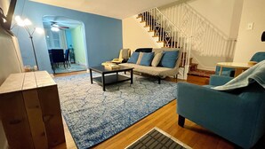 Un salon moderne avec un canapé, une table basse et un escalier.