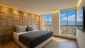 Un dormitorio moderno con una cama grande, vistas a la ciudad y un diseño de cabecera único.