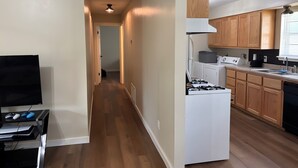 A modern kitchen with wooden cabinets, a white stove, and a black dishwasher.