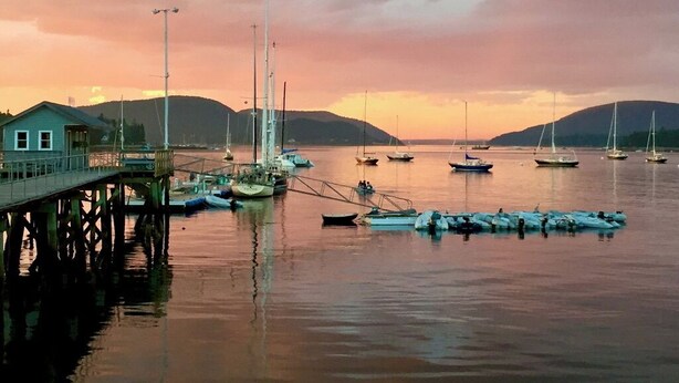 A pier with boats docked at sunset.
