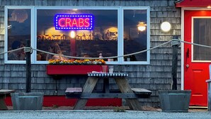 A building with a neon sign reading "CRABS" and a red door.