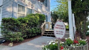 A private driveway sign with a house in the background.