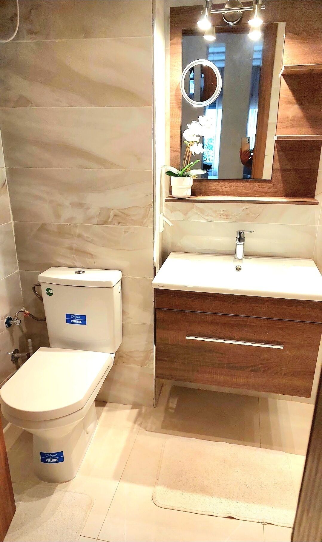 Une salle de bain avec des toilettes, un lavabo et un miroir.