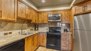 A kitchen with wooden cabinets, a stainless steel refrigerator, a microwave, a stove, and a dishwasher. - NEW PRICE-Sedona Summit Resort-9/2/25-9/7/25, 2 Bedrooms, Sleeps 8-Best Location (Sedona)