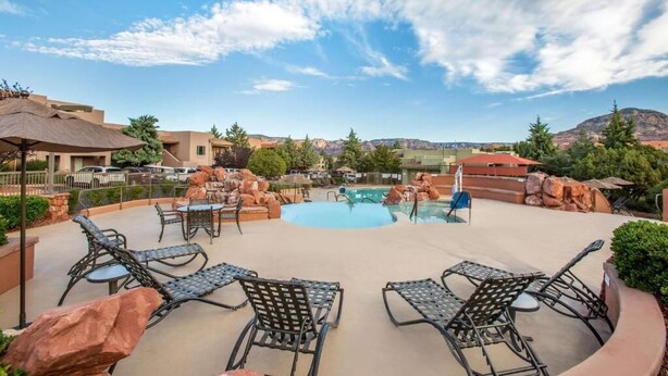 An outdoor pool area with lounge chairs and a view of the surrounding landscape. - NEW PRICE-Sedona Summit Resort-9/2/25-9/7/25, 2 Bedrooms, Sleeps 8-Best Location (Sedona)