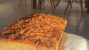A loaf of bread on a cloth, with a dining table and chairs in the background. - Warm house, away from the noise of the city. (Santa Cruz de la Sierra)